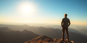 A focused person looking towards a bright, distant horizon.